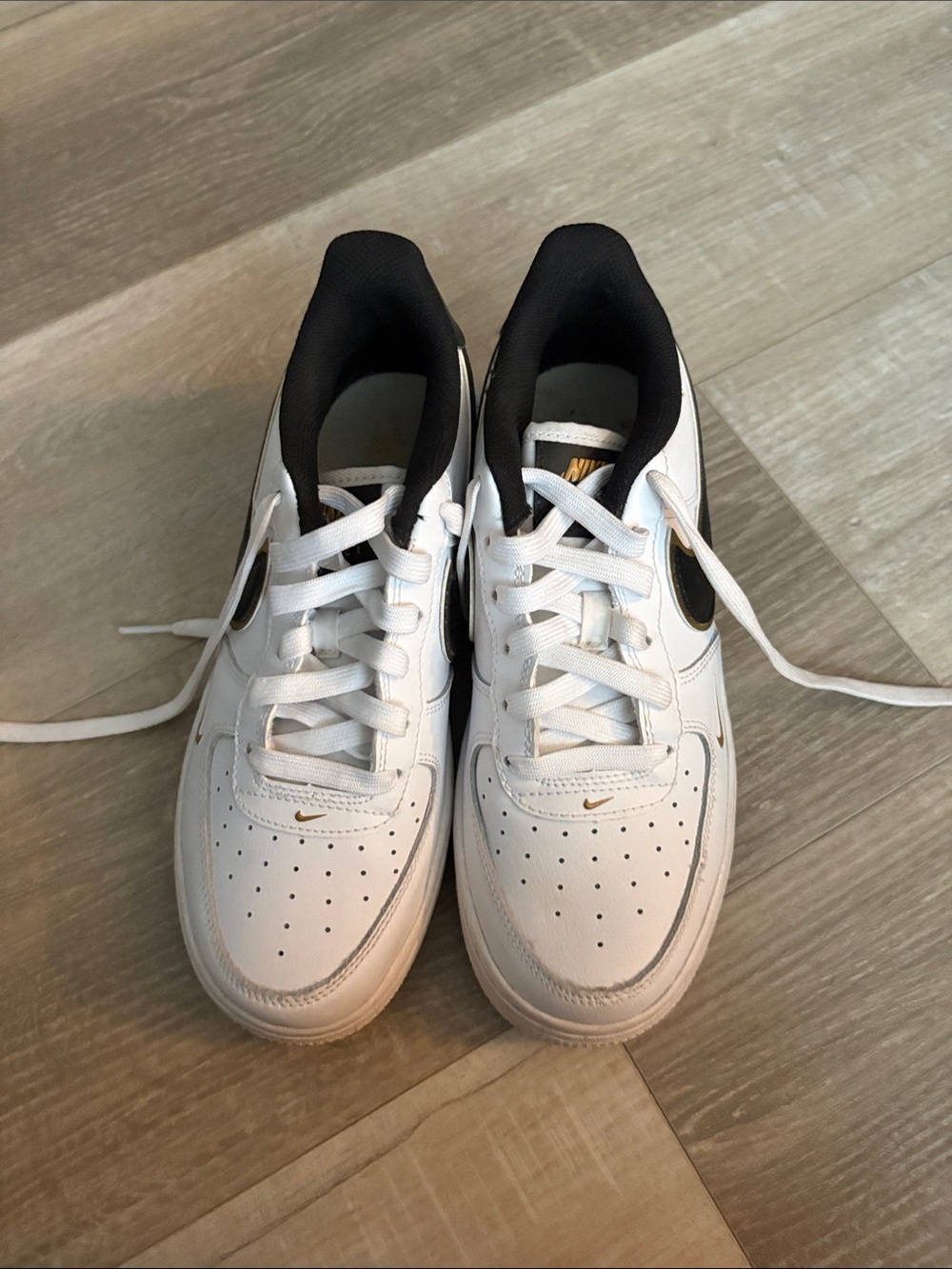 Nike White and Black Low-Top Sneakers with Gold Swoosh